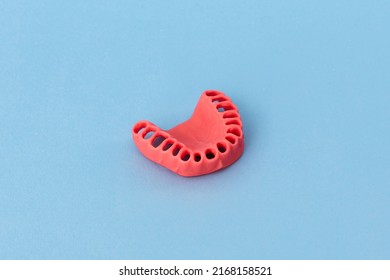 Human Gums Without Teeth Model Medical Implant Isolated On Blue Background. Healthy Teeth, Dental Care And Orthodontic Concept.