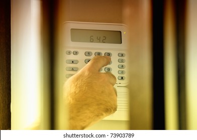 Human Hand Arming A Burglar Alarm System. The View Is Similar As A Spy View This Situation.