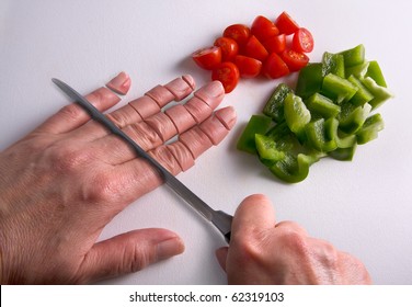 A human hand is being chopped with a knife on a cutting board.