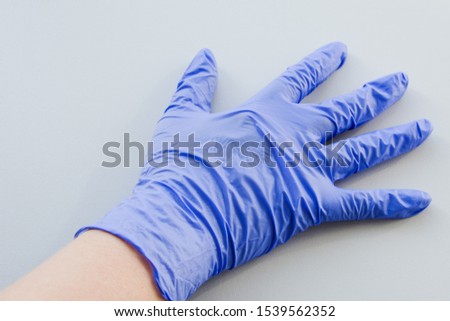 Human hand in blue latex glove, personal protective equipment medical accessory to ensure the safety of staff and patient.  Protect the skin in contact with toxic substances, compliance with sterilit Imagine de stoc © 