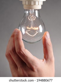 Human Hand Changing A Light Bulb