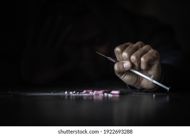 Human Hand Of A Drug Addict And A Syringe With Narcotic Syringe Lying On The Floor. World Anti-drug Day. 