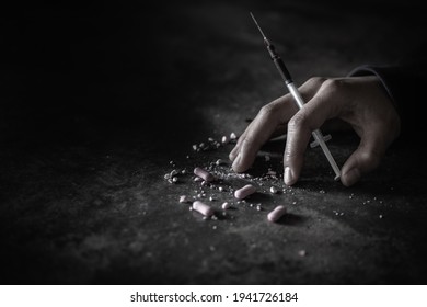 Human Hand Of A Drug Addict And A Syringe With Narcotic Syringe Lying On The Floor. World Anti-drug Day. 