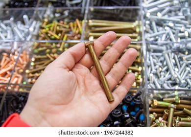 Human Hand Holding A Big Metal Bolt On A Background Of Hardware Store Counter