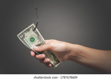 Human hand is holding a dollar on the fishing hook close up on gray background. - Shutterstock ID 1787678609