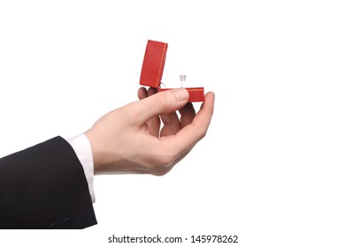 Human Hand Holding A Gift Box With Engagement Ring Inside On White Background