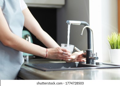 Handglas, das frisches Trinkwasser in der Küchenwache gießt