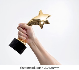 Human hand holding golden star trophy. - Shutterstock ID 2194001949