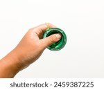 Human hand holding a green yoyo in a white background