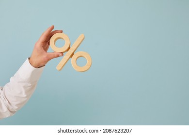 Human hand holding percent symbol. Entrepreneur or client holding percentage sign on blank blue color text copyspace background. Business, finance, mortgage rates, value added tax, or discount concept - Shutterstock ID 2087623207