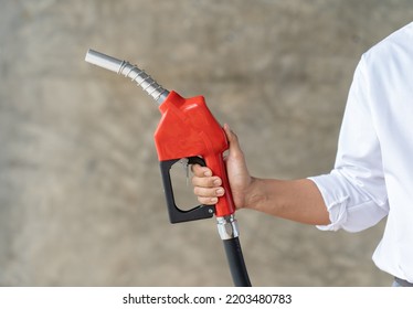 Human Hand Is Holding Red Gasoline Pistol Pump Fuel Nozzle.