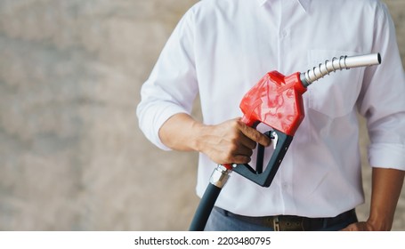 Human Hand Is Holding Red Gasoline Pistol Pump Fuel Nozzle.