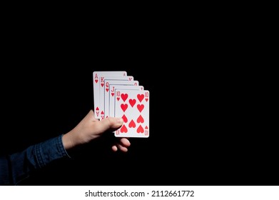 Human Hand Holding A Set Of Royal Flush On The Dark