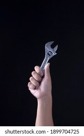 human hand holding a silver wrench - Shutterstock ID 1899704725