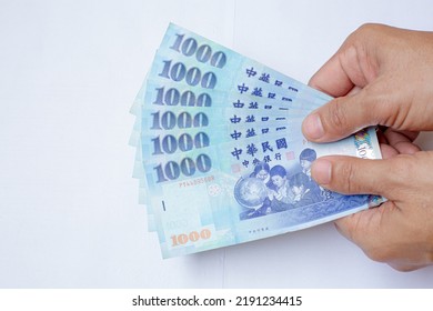Human hand holding  Taiwan  money isolated on white background.Cash, Taiwan currency, money, Taiwan Coin, Taiwan money,Taiwan Dollar money.