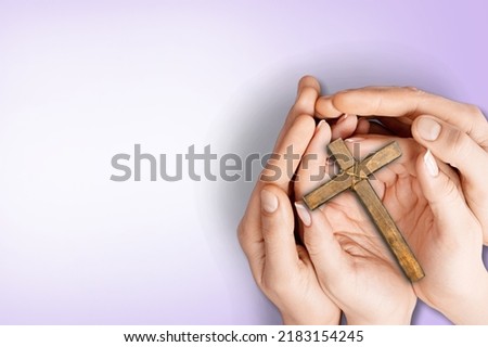 Human hand holding wooden cross crucifix. Catholicism, Christianity, Thanksgiving, Catholic and Christian faith concept.
