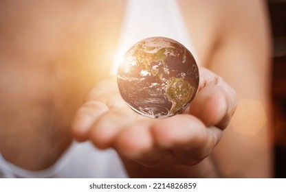 Human Hand Holding The World Earth Above Blue Natural Background. Safe World Concept.. Safe World Concept. Elements Of This Image Furnished By NASA