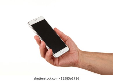 Human Hand Holds A Modern Smartphone With A Blank Chromakey Screen In A Palm. Technology And Advertising Concept. Detailed Closeup Studio Shot Isolated On Abstract Blurred White Background