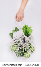 Human Hand Holds String Bag Mesh With Vegetables And Fruits