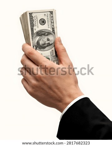 A human hand holds a substantial stack of American currency symbolizing prosperity and economic power