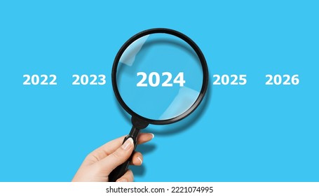Human hand with magnifier and 2024 numbers - Shutterstock ID 2221074995