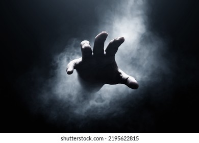 Human hand on dark background - Shutterstock ID 2195622815