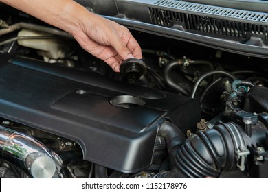 Human hand is opening the car engine oil cap to check the machine