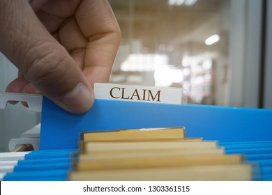 Human Hand Is Picking Up The Claim Document In The File For The Client To The Insurance Company.insurance Concept.