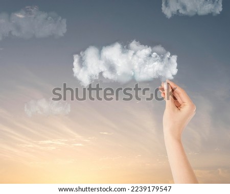 A human hand picking a cloud up