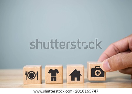 human hand placing cube with food Clothing, housing, medicine, four basic human needs concept.