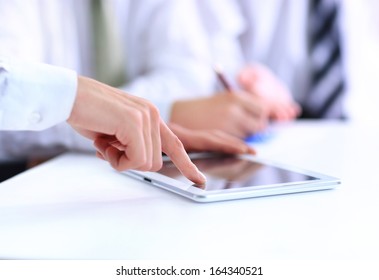  human hand pointing at touchscreen in working environment at meeting