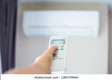 human hand press on remote control of Air Conditioner with hot weather. Subject is blurred. - Shutterstock ID 1385799044