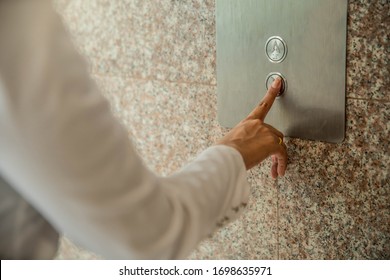 Human Hand Pressing The Last Floor Button In The Elevator. Person Pushing Down Arrow Elevator Button. Businessman Pressing On Elevator Button, Waiting Door Open To Enter Inside The Lift.