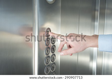 Human hand pressing the last floor button in the elevator