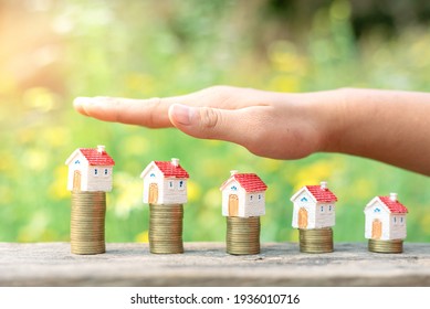 Human hand protective money coin stack with house model .Property investment and house mortgage financial concept, 