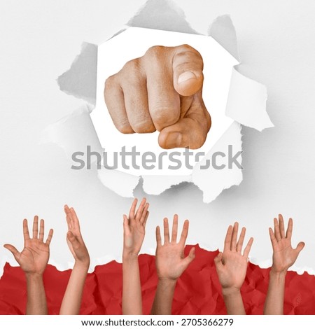 Human hand reaching through a torn white paper hole pointing directly forward at the viewer while diverse hands are raised in the air below in a bright studio setting capturing a powerful message of leadership and collective community engagement