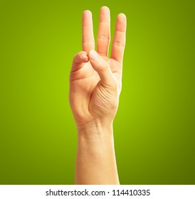 Human Hand With  Two Fingers Pointing Up On Green Background