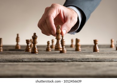 Human hand wearing business suit moving dark King chess piece at table. Conceptual of problem solving.