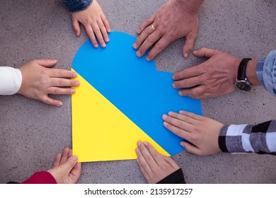 Human Hands Around A Heart With The Colors Of The Ukrainian Flag. Unity, Solidarity And Support For Ukraine. No To War.