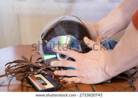 Human hands browsing physical audio media collection for music archive and media selection concepts