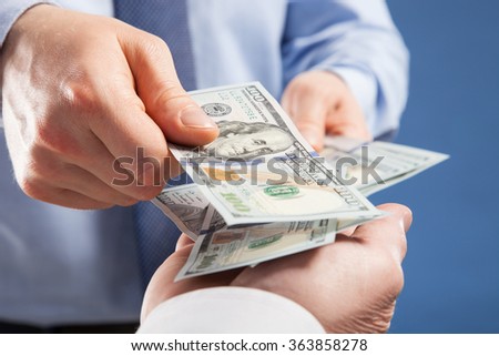 Human hands exchanging money on blue background, closeup shot