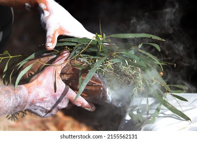 Human hands with green branches of eucalyptus, preparation to the fire ritual rite at a community event in Australia,

