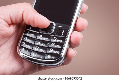Human Hands Hold The Old Mobile Phone With A Blank Screen
