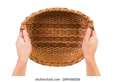 Human hands hold a wicker basket. Wicker basket made of willow branches and shavings. Isolated over white background. Close-up.