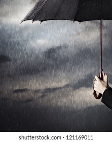 Human Hands Holding Big Black Umbrella Under The Heavy Rain