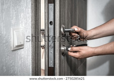 Human hands inserting key into door lock. Security and home access concept. industrial theme