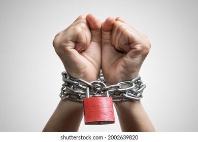 Human Hands Are Linked By A Chain With A Red Padlock. Trafficking, Slavery, Domestic Violence. Concept