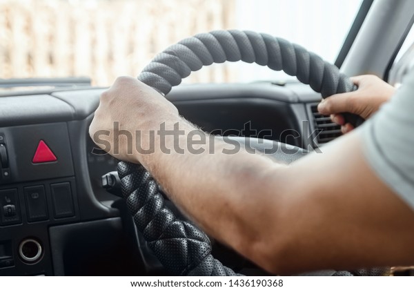 Human hands\
on the steering wheel. An ordinary person driving a car. Driving,\
transportation, travel,\
adventure.