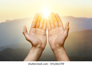 Human hands open palm up worship. Christian Religion concept with light