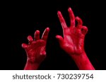 Human hands painted in red are posing on a black background.